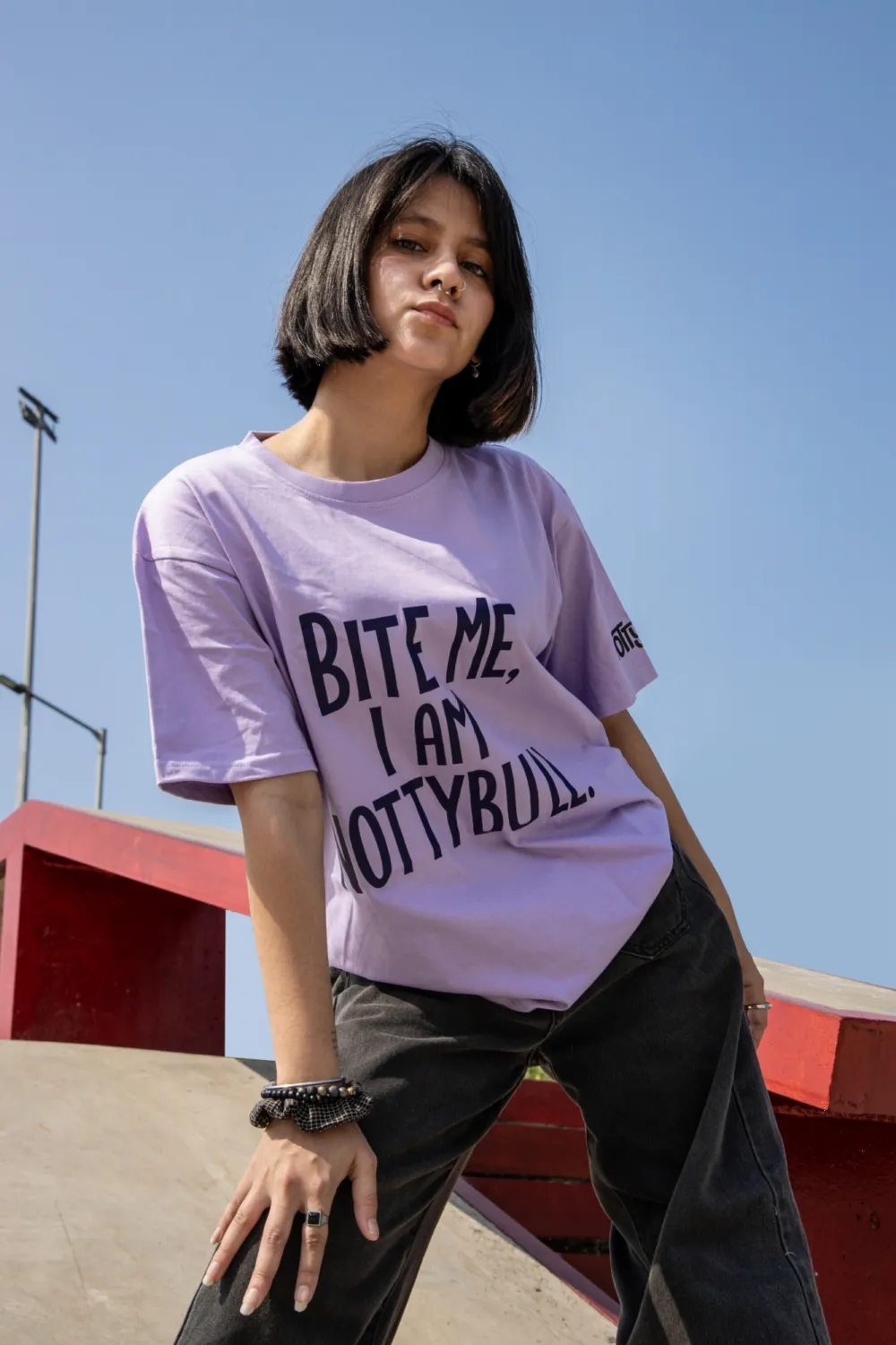 Model in the lilac Bite Me, I Am NottyBull tee at the skate park